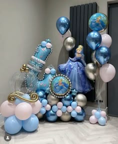 a room filled with balloons and princess figurines on top of the floor next to a wall