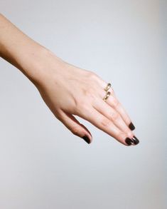 a woman's hand with two gold rings on her left and the other hand