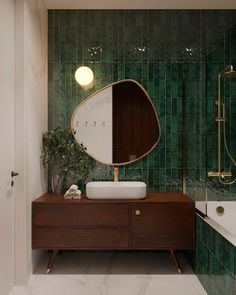 a green tiled bathroom with a sink, mirror and bathtub