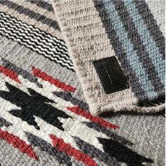 closeup of the label on a multicolored knitted sweater with black stitching