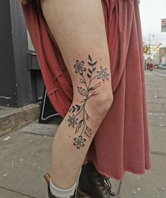 a woman's leg with a flower tattoo on her left arm and the bottom part of her legs