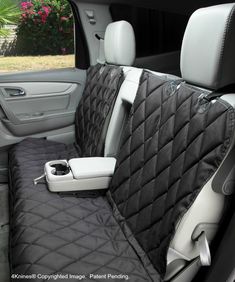 the interior of a car with black and white quilted seat covers on it's back