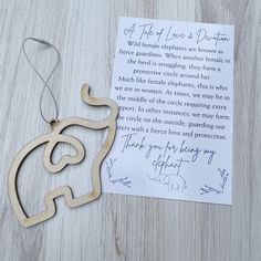 a wooden ornament with a handwritten note attached to it on a table