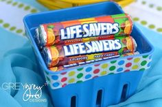 two life savers candy bars sitting in a blue plastic container on a tablecloth