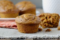 some muffins are sitting on a table next to a cup of coffee and a napkin