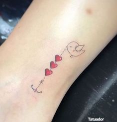 a small heart tattoo on the ankle that says love with two birds flying over it