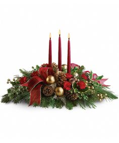 a christmas centerpiece with candles and evergreens in red, gold and green colors