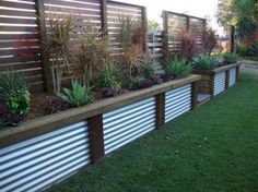 a long wooden planter filled with lots of plants