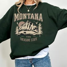 "Montana Sweatshirt, Montana Vacation Sweater, Trendy Sweatshirt, Mountain Mama Gift: This cozy sweatshirt features a captivating mountain graphic in shades of pink. Crafted for comfort and warmth, this trendy sweatshirt is the perfect blend of fashion and functionality making it your go-to choice for chilly days. Make a statement and showcase your love for Montana's majestic scenery with this unique and stylish sweatshirt. Perfect for yourself or as a thoughtful gift for anyone who appreciates The Treasure State.  🎄🎁 IMPORTANT : CHRISTMAS DELIVERY CUTOFF: ORDER BY DECEMBER 11TH! 🎁🎄 NOTE Mockups are used for demonstration purposes only, and the final product may vary slightly in color & placement. SIZE & FIT: Unisex Heavy Blend™ Crewneck Sweatshirt Design is scaled down on smaller size Fall Hiking T-shirt With Graphic Print, Long Sleeve T-shirt For Fall Adventure, Oversized Letter Print Tops For Outdoor, Trendy Long Sleeve Outdoor Sweatshirt, Trendy Long Sleeve Sweatshirt For Outdoor, Fall Hiking Sweatshirt Crew Neck, Fall Hiking Crew Neck Sweatshirt, Fall Crew Neck Sweatshirt For Hiking, Oversized Graphic Print Sweatshirt For Outdoor