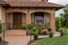 a house that has some plants in the front yard and landscaping on the steps to it