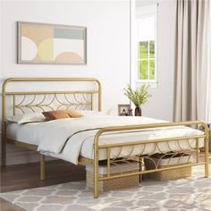 a bed with white sheets and gold frame in a living room next to a window