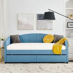 a living room with a blue couch and yellow throw pillows on the backrests