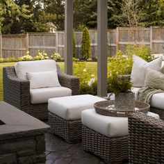 an outdoor patio with wicker furniture and white cushions