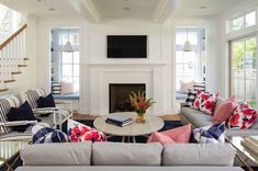 a living room filled with furniture and a flat screen tv mounted on the wall above a fire place