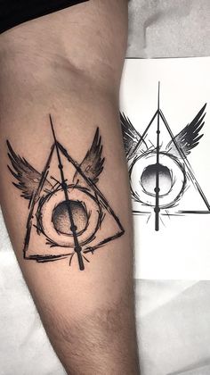 a tattoo on the leg of a man with an eye and two wings in it