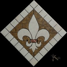 a white and brown tile with a fleur de lis design on the side