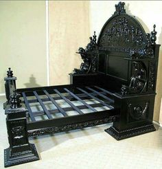 the bed is made with black wood and has intricate carvings on it, as well as an ornate headboard