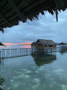 some huts that are sitting in the water near each other on stilfets over looking the ocean