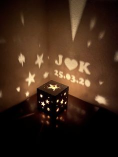 a cube with stars on it sitting in front of a light that is projected onto the wall