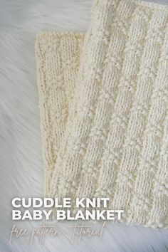 the crochet baby blanket is knitted in white yarn and sits on a fur rug