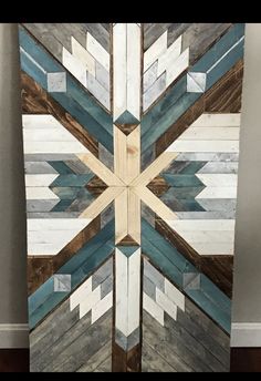 an art piece made out of wood and painted with blue, white and brown colors