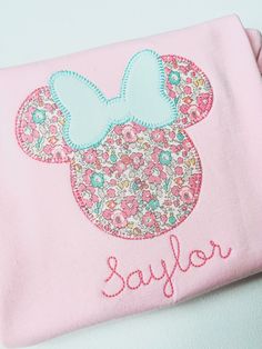 a minnie mouse applique on a pink t - shirt with the word saylor