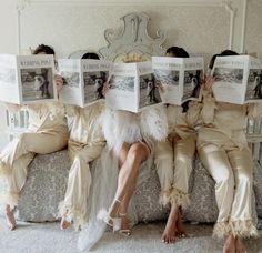 four people are sitting on a couch with newspapers in their hands and one person is reading