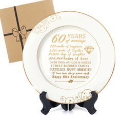 a 50th anniversary plate with a gift box in the back and a card on top