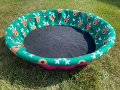 a dog bed in the grass with reindeer and snowflakes on it's sides