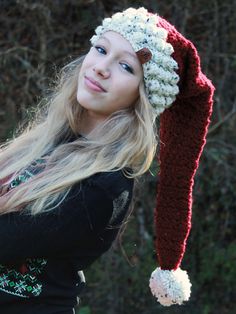 a woman wearing a crocheted hat with pom - poms