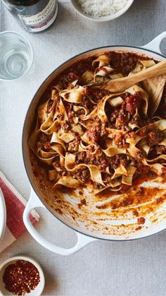 a pan filled with pasta and sauce on top of a table