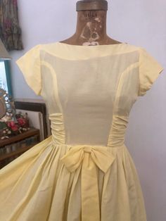 🌿FOR SALE🌿1950s yellow fit and flare party dress. High wide neck with cap sleeves. I love the waist side ruched detail. Center bow waist detail. Full skirt. One mark on the skirt- please see photo. Otherwise great condition. Best for xxs-xs. Priced as is. MEASUREMENTS(taken flat, double when appropriate) PTP 17, Waist 12 1/2-13, hips open, length 38 This is the perfect unique gift for a loved one, or yourself! Please be sure to email all questions before purchasing as I do not take returns. In Vintage Ruched Dress With Fitted Bodice, Vintage Cap Sleeve Dresses, Yellow Vintage Dress For Garden Party, Yellow Retro Vintage Dress For Garden Party, 1950s Style Yellow Dress For Garden Party, Fitted Yellow Dress With Pleated Bodice, Yellow 1950s Style Dress For Garden Party, Yellow Fitted Dress With Pleated Bodice, 1950s Style Yellow Party Dress