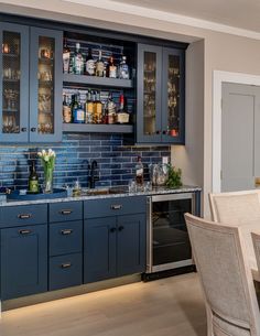 a kitchen with blue cabinets and marble counter tops is seen in this image from the dining room