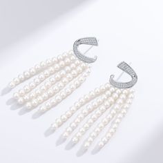 Transform your look with our Luxurious Curved Cubic Zirconia & Multi-Chain Pearl Earrings, a sophisticated blend of sparkle and elegance. The design features a gracefully curved band of brilliant cubic zirconia at the top, leading to five delicate chains adorned with lustrous 3-4mm freshwater pearls. Crafted meticulously in sterling silver, these earrings exude opulence and charm, making them a striking accessory for luxury events or whenever you desire to infuse a touch of glamour into your att Elegant Cubic Zirconia Chandelier Earrings For Evening, Elegant Evening Chandelier Earrings Cubic Zirconia, Elegant White Diamond Dangle Earrings, Elegant White Cubic Zirconia Bridal Earrings, Elegant Chandelier Earrings For Evening Events, White Cubic Zirconia Evening Earrings, Evening White Cubic Zirconia Earrings, Elegant White Cubic Zirconia Earrings, Elegant White Diamond Earrings With Elegant Design