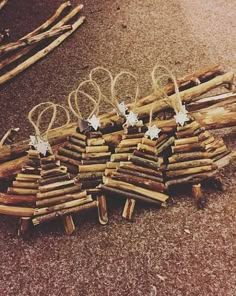 several pieces of driftwood are arranged on the ground with white stars hanging from them