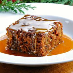 a piece of cake sitting on top of a white plate covered in caramel sauce