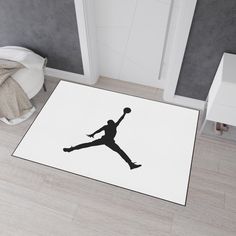 a black and white photo of a basketball player on the floor in a room with grey walls