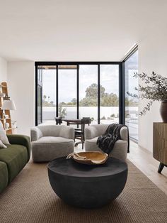 a living room filled with furniture and large windows