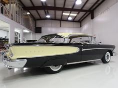 an old black and white car in a garage