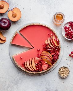 a pie with apples, cherries and cranberries on it next to other fruit