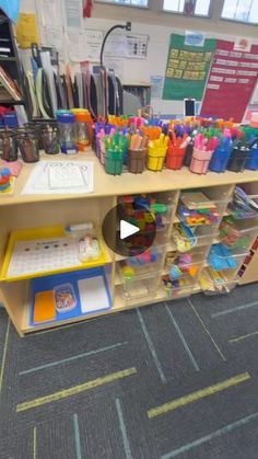 a desk with lots of pens and pencils on it in an office setting,