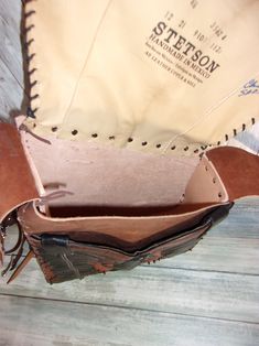 an old leather purse sitting on top of a wooden floor