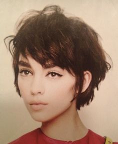 a young woman with short hair wearing a red shirt