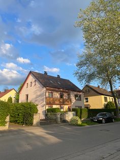 an old house with a car parked in the driveway