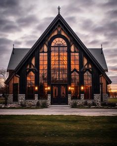 a church with large windows and lights on it's front door is lit up by the evening sun