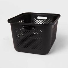 a black basket sitting on top of a white table