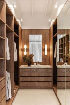 a large walk in closet with two sinks and mirrors