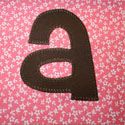 the letter b is made out of fabric and has black letters on pink floral background