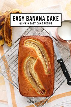 a banana cake sitting on top of a cooling rack next to some bananas and spoons