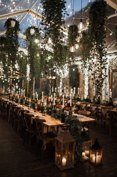 a long table with candles and greenery is set up for an outdoor wedding reception